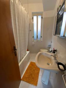 biała łazienka z umywalką i prysznicem w obiekcie Appartamento mare e relax w mieście Gioiosa Marea