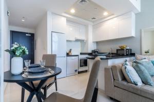 a kitchen and living room with a table and a couch at The Smart Concierge - Damac 108 in Dubai