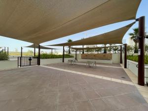 a pavilion with tables and umbrellas on a patio at The Smart Concierge - Damac 108 in Dubai