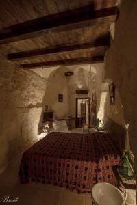 um quarto com uma cama num quarto de pedra em B&B Fiorentini em Matera