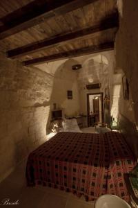 a bedroom with a bed in a stone room at B&B Fiorentini in Matera