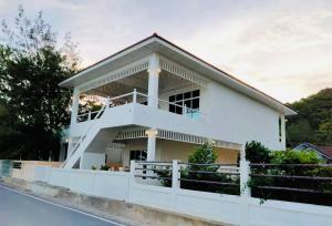 een wit huis met een hek ervoor bij Baan Soulmates in Ban Khung Tanot