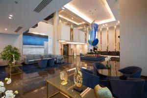 Centara West Bay Hotel & Residences Doha في الدوحة: لوبي فيه كنب وطاولات ومنطاد ازرق