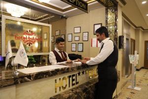 Due uomini in piedi al bancone della reception dell'hotel di Buldum Otel a Ankara
