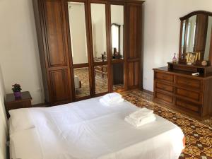リーパリにあるIsola - LIPARI centro storicoのベッドルーム(大きな白いベッド1台、ドレッサー付)