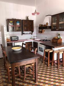 - une cuisine avec une table en bois, des chaises, une table et une table dans l'établissement Isola - LIPARI centro storico, à Lipari