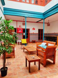 un patio avec des bancs et des tables dans un bâtiment dans l'établissement Vivian's Guest House, à Jerez de la Frontera