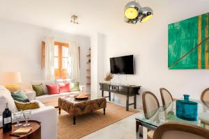 sala de estar con sofá blanco y mesa en Genteel Home Zaragoza, en Sevilla