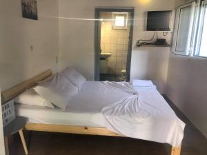 a bed with white sheets and pillows in a room at Karampinis in Kaloi Limenes
