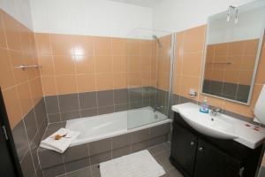 y baño con bañera y lavamanos. en Best Of Xlendi SeaFront Apartments, en Xlendi