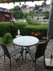 a white table and two chairs on a patio at Ferienwohnung Tuchscherer in Cranzahl