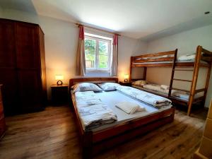 a bedroom with two bunk beds and a window at Penzión na Hálni in Nižná Boca