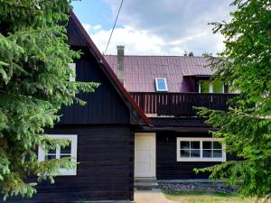 a black house with a red roof at Penzión na Hálni in Nižná Boca