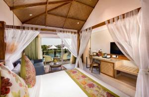 Schlafzimmer mit einem Bett und einem Schreibtisch mit einem TV in der Unterkunft Swosti Chilika Resort in Kānāipur