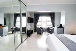 a hotel room with a bed and a mirror at Augusta Palms in Centurion