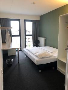 um quarto de hotel com uma cama e uma secretária em The ASH em Antuérpia