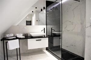 een badkamer met een wastafel en een glazen douche bij Apartamenty Royal Maris 4 - najlepsza lokalizacja w Ustce, blisko plaży i portu, bezpłatny parking, ścicsłe centrum in Ustka +54 foto's