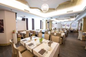 Palace Hotel Città في آركو: مطعم فيه طاولات وكراسي في الغرفة