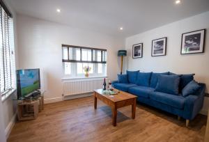 a living room with a blue couch and a table at Southgate Coach House in Dorchester