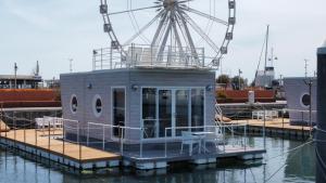 里米尼House Boat Rimini Resort的一艘在水面上装有摩天轮的小船