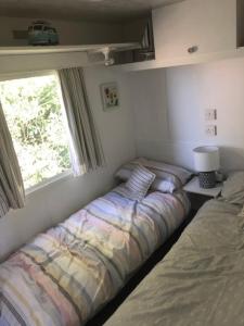 Een bed of bedden in een kamer bij Cosy and rural Lodge at Goldhill Glamping