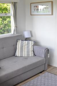 un sofá con una almohada en la sala de estar en Cosy and rural Lodge at Goldhill Glamping en Shaftesbury