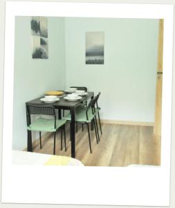 a dining room with a black table and chairs at Apartament w Alei Fontann. in Szczecin