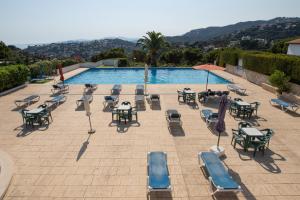 un patio con mesas y sillas junto a una piscina en SANTA MONICA - ENERGiA MEDITERRANEA, en Tossa de Mar