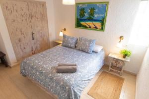 una camera da letto con un letto con un piumone blu di CBA COSTA BRAVA - Santa Monica a Tossa de Mar Altre 32 foto