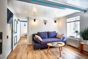 een woonkamer met een blauwe bank en een tafel bij fewo1846 - Hafen-Butze - komfortable Wohnung in historischem Gebäude im Stadtzentrum in Flensburg