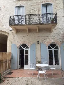 ein Balkon an einem Gebäude mit einem Tisch und Stühlen in der Unterkunft SENTIMIR in Saint-Génis
