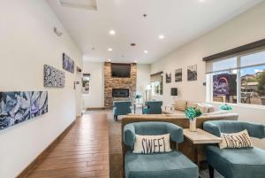 - une salle d'attente avec des chaises, une table et un canapé dans l'établissement Sleep Inn Flagstaff, à Flagstaff