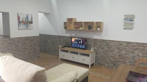 ein Wohnzimmer mit Sofa und Fernseher in der Unterkunft FINCA VILLA ZAAR HOMES in Puerto Real