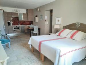 a bedroom with a large bed and a kitchen at Un Coin De Luberon in L'Isle-sur-la-Sorgue