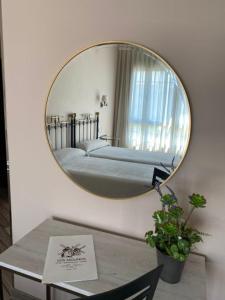 a mirror in a room with a bed and a table at Hotel Los Molinos in Llanes