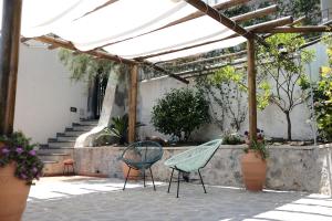 d'une terrasse avec 2 chaises et une pergola. dans l'établissement DAME casa vacanza, à Amalfi