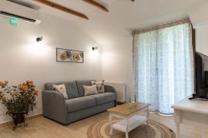 a living room with a couch and a tv at Villa La Varik 2 in Litochoro