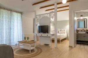 a living room with a bed and a television at Villa La Varik 2 in Litochoro