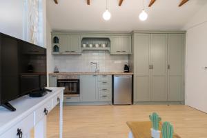 a kitchen with white cabinets and stainless steel appliances at Villa La Varik 2 in Litochoro