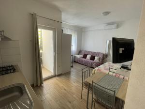 a kitchen and living room with a couch and a table at Apartmani Jasminka in Vodice