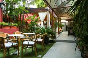 an outdoor patio with tables and chairs and plants at Hotel Regal in Costinesti