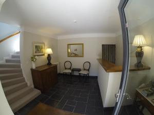 a hallway of a home with stairs and two chairs at Auberge de la Sagne in Cabrerets