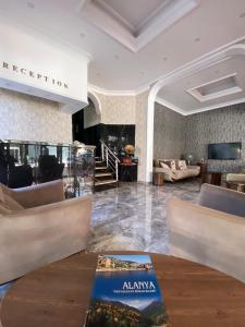 un vestíbulo de un hotel con mesa y sillas en Sempati Apart Hotel, en Alanya