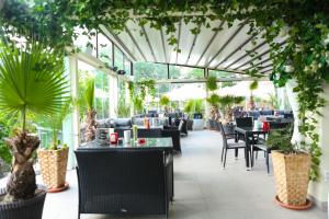 a restaurant with tables and chairs and plants at Hotel Regal in Costinesti
