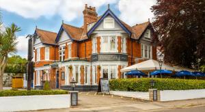 a large red brick building with a sign in front of it at Inn in the Park in Bournemouth