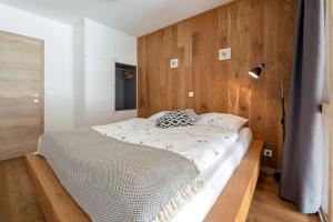 a bedroom with a bed with a wooden wall at SKI Gothia in Kranjska Gora