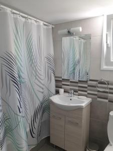 a bathroom with a sink and a shower curtain at Ikaria Village Maisonette 12 in Paphos