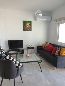 a living room with a couch and a table at Ikaria Village Maisonette 12 in Paphos +44 photos