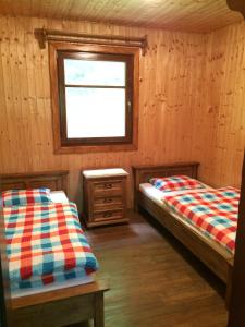 a bedroom with two beds and a window and a table at Chata Sklene Teplice in Sklené Teplice