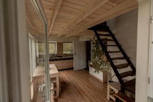 a living room with a staircase and a kitchen at Дача рибача in Svityazʼ